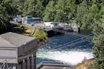 Water streams under Dam 2 and towards the raw water intake at the Bull Run Watershed, July 16, 2024. The Portland Water Bureau is currently running a pilot program, housed in the blue buildings at top left, to fine tune the process of filtering out cryptosporidium and wildfire ash from the water.