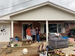 Khyland Stephenson and Angela Stephenson, his mother, with Trudy Hall, in front of Hall's flooded home. Stephenson is Hall's co-worker at a nursing home and brought lunch for her.