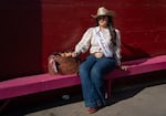 Miss Rodeo Arkansas Ambassador Falyn Cordeiro poses for a portrait outside the grandstand in Pendleton, Ore., on Sept. 16, 2026. She wears a Resistol hat with Wrangler shirt and jeans, and a leather bag emblazoned with her signature.