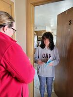 Biden campaign volunteer Sarah Harrison speaks with voter Autumn Dietscher on March 16 about Waukesha School Board elections and Wisconsin's presidential primary.