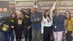 (left to right) KMHD's Blaire Stapp, Nicole D'Amato, Anthony Dean-Harris, Rev Shines, Bri Drennon, Alex Newman, and Meg Samples pose with a new collection of KMHD thank-you gifts.