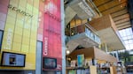 Inside of a library with shelves of books and brightly colored walls.