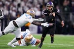 Washington quarterback Demond Williams Jr. (2) runs the ball against UCLA linebacker Oluwafemi Oladejo (2) during the second half of an NCAA college football game Friday, Nov. 15, 2024, in Seattle. Washington won 31-19. 