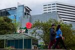 People walk along the waterfront in Portland, Ore., Thursday, April 29, 2020. The word "hope" was placed on the neon rose sign in response to the COVID-19 pandemic.