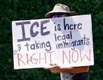 A protester holds a sign across the street from the U.S. Immigration and Customs Enforcement office in Portland, June 11, 2025, opposing the Trump administration's immigration enforcement actions.