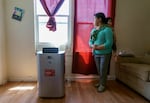 FILE - Juana Pascual Pascual holds her child at their second-floor Portland apartment where they have lived for six years. She said her family suffered during 2021’s heat dome, with just bottled water to find relief. In 2022, she received a free cooling/heating unit through the Portland Clean Energy Fund working with Verde.