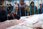 Palestinians mourn the relatives killed in the Israeli air and ground offensive on the Gaza Strip at a hospital in Deir al Balah on Jan. 26.