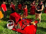 Participants brought the red dresses to a blanket and chair setting, intended to honor MMIW/MMIG victims on Wednesday May 4, 2022. A basket of tobacco-filled pouches and a rawhided drum also complemented the arrangement.