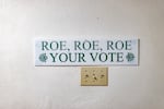 A sign reading "Roe Roe Roe Your Vote" is pictured in an Arizona building before the election.