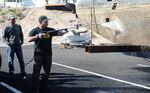 Stan Wong, a concessions manager at Lake Chabot, removes quagga mussels from a boat during a Watercraft Inspection Training course at Lake Mead, Nevada, Nov. 14, 2012.