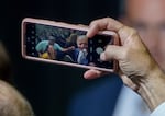 President Joe Biden holds a phone and takes a selfie of himself with attendees, following his appearance at East Portland Community Center in Portland, in October.
