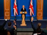 Journalists raise their hands for questions as Britain's Prime Minister Liz Truss holds a news conference in the Downing Street Briefing Room in central London, Friday. Truss let go her finance chief Kwasi Kwarteng and reversed course on sweeping tax cuts.
