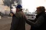 Altadena residents FaceTime a loved one as they watch their home burn in the Eaton Fire on Wednesday that has currently taken the lives of 5 people and burned over 2000 structures, forcing over 100,000 residents to evacuate Altadena, California, United States on January 8, 2025. (Photo by Jon Putman/Anadolu via Getty Images)