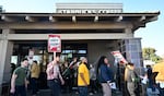 Starbucks workers hold signs as they picket in Burbank, California on Friday.