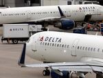 U.S. airline regulators have opened an investigation into Delta Air Lines, which was still struggling to restore operations on Tuesday, more than four full days after a faulty software update caused technological havoc worldwide and disrupted global air travel. Here, a Delta Air Lines plane leaves the gate on July 12, 2021, at Logan International Airport in Boston.