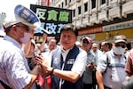 Leader of the Kuomintang (KMT) caucus at the Legislative Yuan Fu Kun-chi (C) shakes hands with supporters outside of the Legislative Yuan
