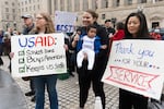 United States Agency for International Development (USAID) supporters hold banners as USAID workers retrieve their personal belongings from the USAID's headquarters in Washington, Thursday, Feb. 27, 2025.