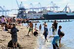 Kids splashed in the waves at the Puyallup Canoe Landing on July 31, 2024 as canoe families from all across the Pacific Northwest took turns approaching the shore and asking representatives from the Puyallup Tribe of Indians for permission to land.