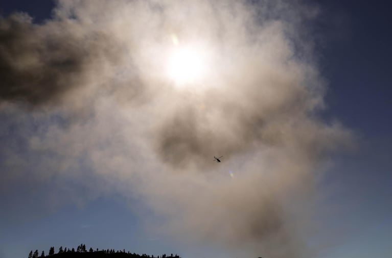 A helicopter flies through the smoke emitted by the oil train fire in Mosier on Friday, June 3, 2016.