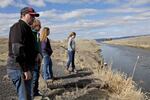 FILE - In this March 2, 2020, file photo, farmer Ben DuVal with his wife, Erika, and their daughters, Hannah, third from left, and Helena, fourth from left, stand near a canal for collecting run-off water near their property in Tulelake, Calif. The Klamath Basin, a vast and complex water system that spans Oregon and California, is in the throes of the worst drought in recorded history, with water flows in the tributaries of the Klamath River that are as low as they have been in a century. Federal officials are expected to announce the water allocations for the season this week and it's possible that farmers might not get any water at all.