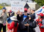 A supporter holds a sign reading "Our Favorite Felon" outside a fundraising event for Donald Trump on Thursday.