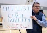 Crook County English as a second language teacher Jason Ritter holds a protest sign alleging school officials had a “hit list” of people deemed to be ideological enemies at a Jan. 6, 2025 special meeting of the school board. "I'm here as a parent," says Ritter. "There has been some undue scrutiny and attention focused on various programs headed by individuals that were purportedly on that hit list."