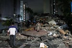 People walk amid debris after an earthquake in Caracas, Venezuela, Wednesday, June 24, 2026.