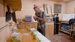 A scientist smelling hop flowers in a room.