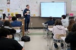 David Mann, center, an English teacher at Waldo Middle School in Salem, Ore., responds to student David "DJ" Jennings, right front, during class on May 19, 2025.
