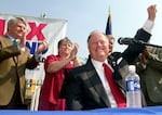 Sen. Max Cleland, D-Ga., foreground, raises his hand to the crowd at a campaign rally in downtown Atlanta on Wednesday, Aug. 21, 2002. Cleland, who lost three limbs to a Vietnam War hand grenade blast yet went on to serve as a U.S. senator from Georgia, died on Tuesday, Nov. 9, 2021. He was 79.