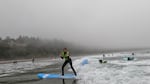 In this image collected from video footage, Siletz tribal member Lexi Jackson catches a wave at Otter Rock Beach in August 2022. "Once you get on and, like, know what you're doing, it's really fun, and you get way better," she says. 