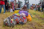 People who crossed from Congo wait for assistance in Gyseny, Rwanda, on Tuesday, following M23 rebels' advances into eastern Congo's capital Goma.