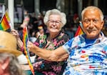 Former Oregon Gov. Barbara Roberts, left, and activist Terry Bean, right, travel together in a convertible car along the parade route.