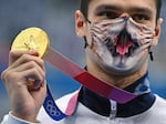 Russian gold medalist Evgeny Rylov, wearing a face covering, poses with his medal after the men's 200m backstroke during the Tokyo Olympic Games in 2021. His challengers questioned whether he competed with the aid of performance enhancing drugs.