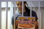 US' Women's National Basketball Association (WNBA) basketball player Brittney Griner, who was detained at Moscow's Sheremetyevo airport and later charged with illegal possession of cannabis, holds a picture of her team as she stands inside a defendants' cage before a court hearing in Khimki outside Moscow, on August 4, 2022.