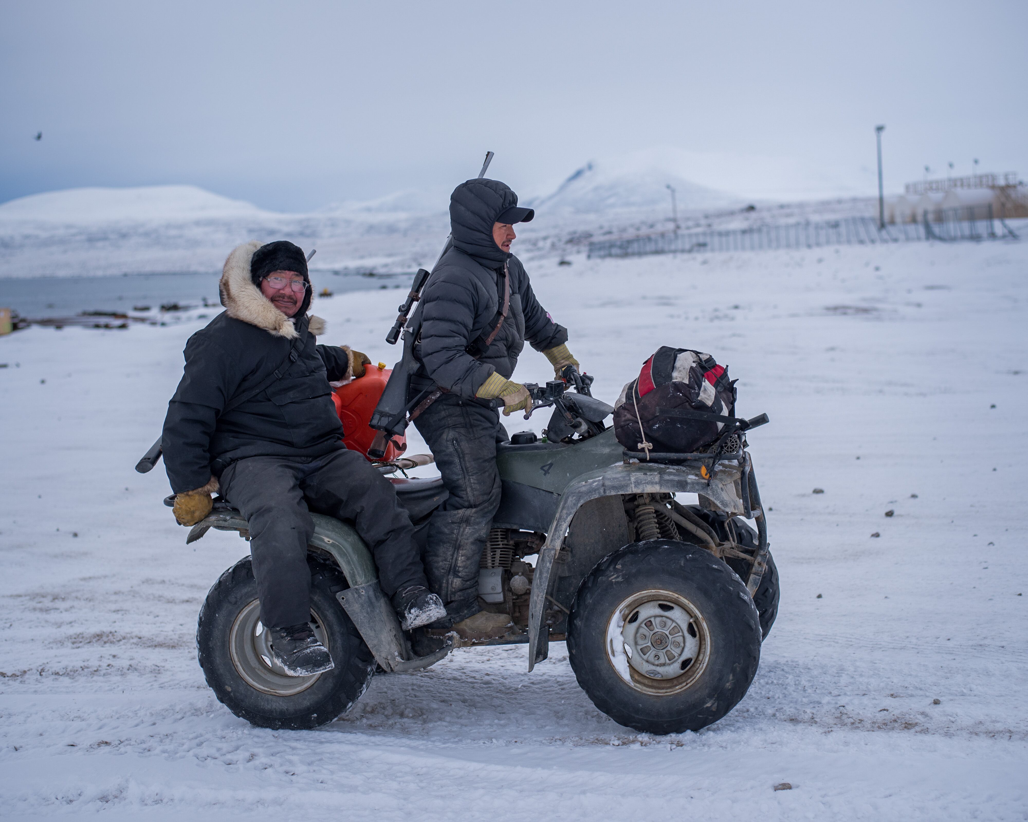 Joanasie Illauq, left, catches a ride home from the Clyde River harbor after hunting for narwhal in October 2016. Inuit people are permitted to hunt these marine mammals.