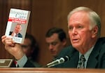 Senate Finance Committee Chairman Bob Packwood, Oregon, holds a book entitled "Intensive Care" by Ross Perot during hearings dealing with the future of Medicare on Capitol Hill Wednesday, Aug. 30, 1995.