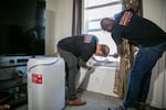 FILE - Rele Martinez, left, and Eduardo Diaz with Cooling Portland install a new portable air conditioning unit in the home of a low-income resident of Portland, Ore, July 1, 2025. The Portland Clean Energy Fund has helped low-income Portlanders access in-home cooling as part of its support for programs that respond to a changing climate. Eugene residents may be asked to consider a tax for a similar program when they vote in November.