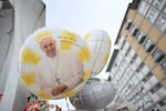Balloons depicting Pope Francis are laid at the statue of John Paul II outside the Gemelli hospital where Pope Francis is hospitalized, in Rome on Feb. 24, 2025. Pope Francis, in critical condition in hospital with pneumonia, had a good night and was resting, the Vatican said Monday.
