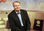 FILE - Charles Osgood, anchor of CBS's "Sunday Morning," poses for a portrait on the set in New York on March 28, 1999.  Osgood, who anchored the popular news magazine's for more than two decades, was host of the long-running radio program “The Osgood File” and was referred to as CBS News’ poet-in-residence, has died. He was 91. (AP Photo/Suzanne Plunkett, File)