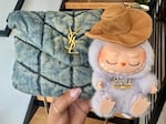 A Labubu doll clipped to a high-end bag is pictured in an undated provided photo.