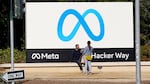 People talk near a Meta sign outside of the company's headquarters in Menlo Park, Calif., March 7, 2023. (AP Photo/Jeff Chiu)