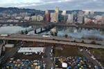 FILE - In this aerial photo, tents housing people experiencing homelessness are set up on a vacant parking lot in Portland, Ore., Dec. 8, 2020. Oregon is bracing for federal housing staff at the U.S. Department of Housing and Urban Development to be laid off amid the state's housing and homelessness crisis.