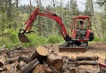 Dale, one of the students OPB has followed as part of its Class of 2025 project, operates a mini-excavator to move wood.