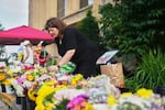 Annique London, a parent volunteer, helps with flowers at a memorial at Annunciation Catholic Church after Wednesday's school shooting, Thursday, Aug. 28, 2025, in Minneapolis. 