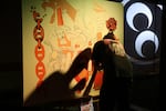 An artist works on a large, bike-themed piece at the One Motorcycle Show in Portland, Ore.