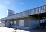 A squat gray building with a sign emerging from the roof that states "City of Burns."