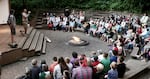 In this undated photo provided by Oregon Summer Star, campers gather around a campfire. During the annual week-long camp, attendees sing songs, perform skits, play volleyball and learn more about their family's lives in the military. Supporters of the camp say it helps children feel less alone during the isolating experience of being apart from an enlisted parent.