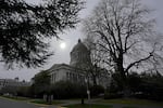 The sun appears through cloudy skies Thursday, March 10, 2022, above the Legislative Building at the Capitol in Olympia, Wash. The Washington state House overwhelmingly approved legislation Wednesday that would ban police from hog-tying suspects, a restraint technique that has long drawn concern because of the risk of suffocation. (AP Photo/Ted S. Warren)