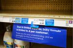 A "due to limited supplies" sign is shown on the baby formula shelf at a grocery store.